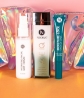 Neora’s Summer Skin Essentials Set, which includes two Age IQ Day Cream, Moisture-Lock Lip Mask and Hydrating Mist with a FREE Holographic Travel Bag lying behind it